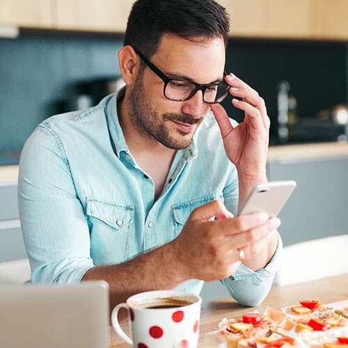 Hombre revisando su teléfono en la cocina.